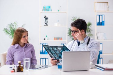 Doktor hastanın röntgen görüntülerini inceliyor.