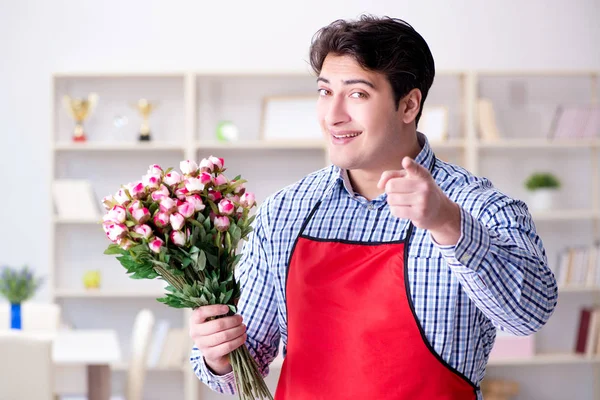 Asistente de floristería ofreciendo un ramo de flores — Foto de Stock