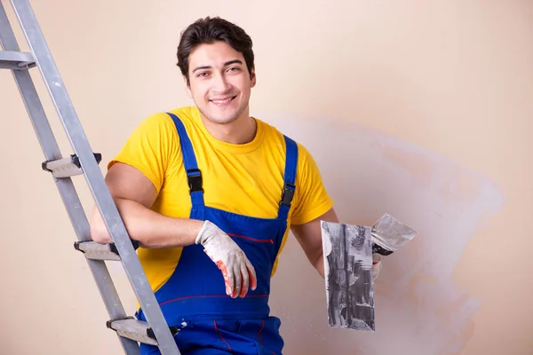 Junger Bauunternehmer verputzt Wand — Stockfoto