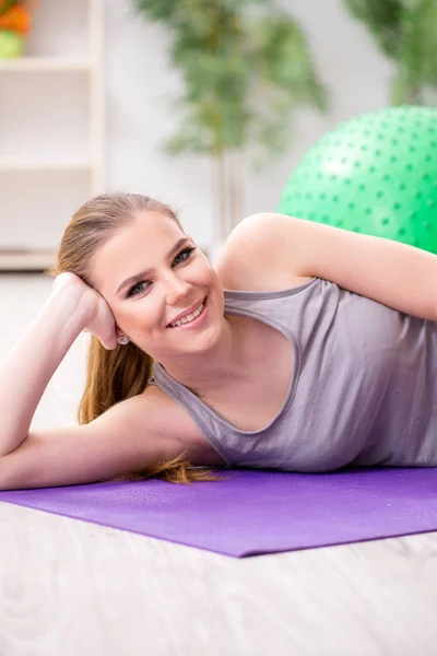 Mujer joven haciendo ejercicio con pelota de estabilidad en el gimnasio — Foto de Stock