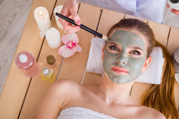 Ung kvinna i spa hälsa koncept med ansiktsmask — Stockfoto