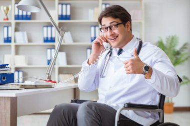 Hastanede çalışan tekerlekli sandalyedeki engelli doktor.