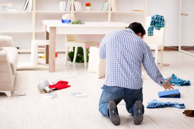 Hırsızlar tarafından soyulduktan sonra evini bulan bir adam.