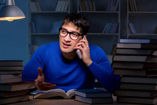 Estudante se preparando para exames tarde da noite na biblioteca — Fotografia de Stock