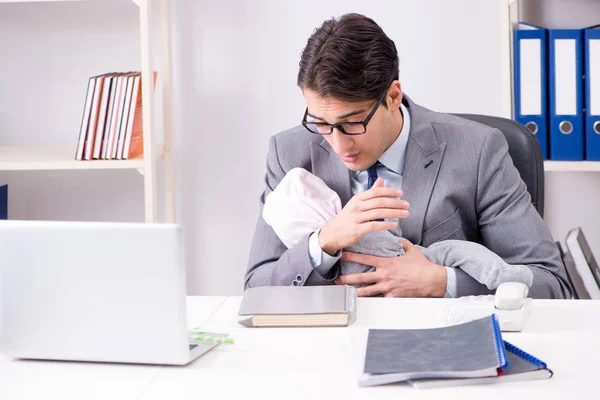 Businessman looking after newborn baby in office