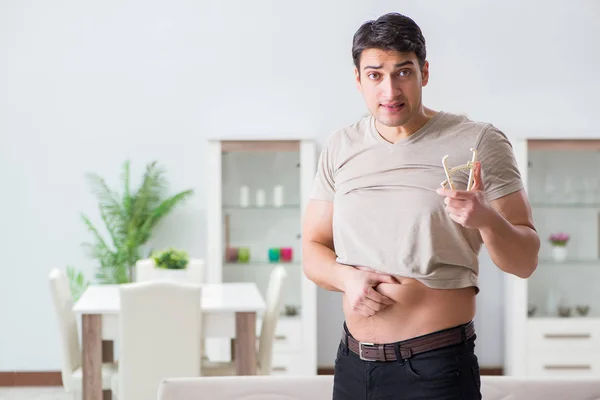 Hombre midiendo grasa corporal con pinzas — Foto de Stock