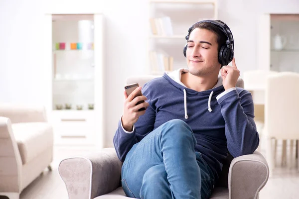Νεαρός όμορφος άντρας ακούει μουσική με ακουστικά — Φωτογραφία Αρχείου