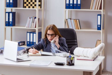 Ofiste bacağı kırık, meşgul bir çalışan.