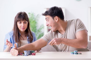 Genç bir aile evde kağıt oynuyor.
