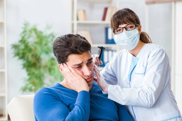 Врач проверяет ухо пациента во время медицинского обследования — стоковое фото
