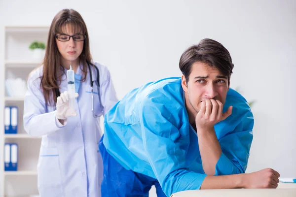 Funny man getting ready for buttocks syringe shot — Stock Photo, Image