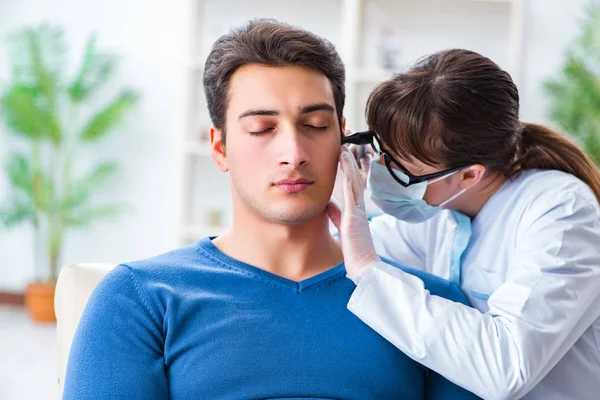 Doctor checking patients ear during medical examination — Stock Photo, Image