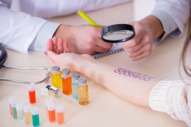 Hastanedeki hastanın alerji reaksiyonunu test eden doktor.