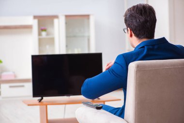İş adamı ofiste televizyon izliyor.