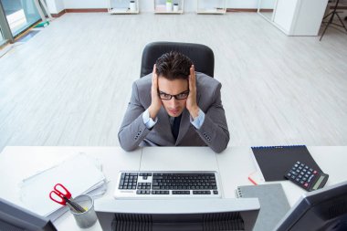 Genç işadamı masasında çalışıyor.