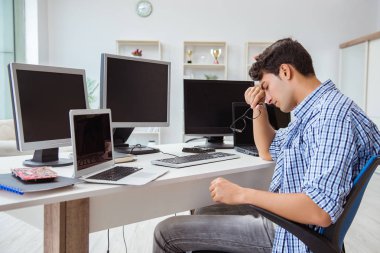 Birçok ekranın önünde oturan bir iş adamı