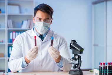 Laboratuvar asistanı hastanede kan örneklerini test ediyor.