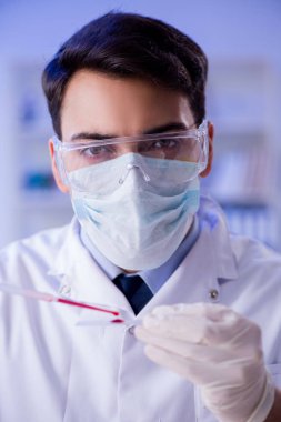 Laboratuvar asistanı hastanede kan örneklerini test ediyor.