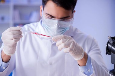 Laboratuvar asistanı hastanede kan örneklerini test ediyor.
