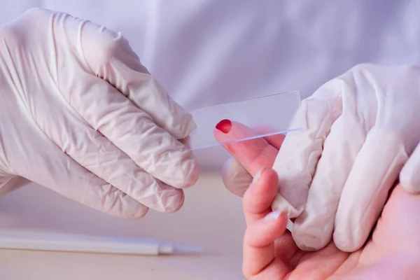 Médecin prélevant des échantillons de sang du doigt — Photo