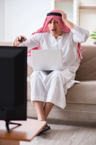 Arab businessman watching tv at home