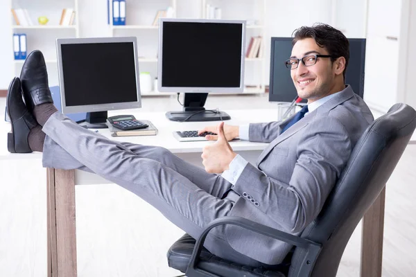 Geschäftsmann sitzt vor vielen Bildschirmen — Stockfoto