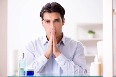 Adam banyoda çalışmak için giyiniyor.