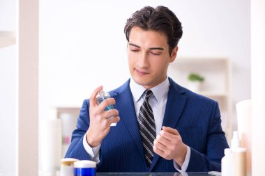 Adam banyoda çalışmak için giyiniyor.