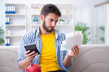 Ödeme yapması gereken faturalara kızgın bir adam.