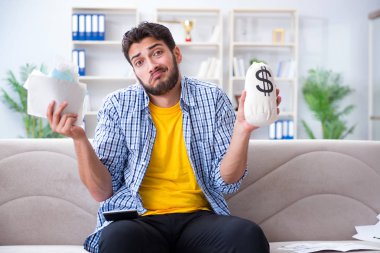 Ödeme yapması gereken faturalara kızgın bir adam.