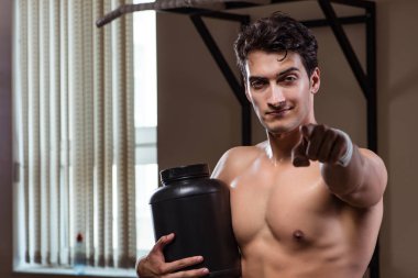 Spor salonunda besin takviyesi olan bir adam.