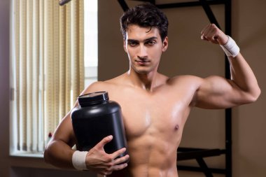 Spor salonunda besin takviyesi olan bir adam.