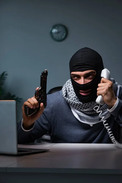 Terroristische inbreker met pistool werkend op computer — Stockfoto