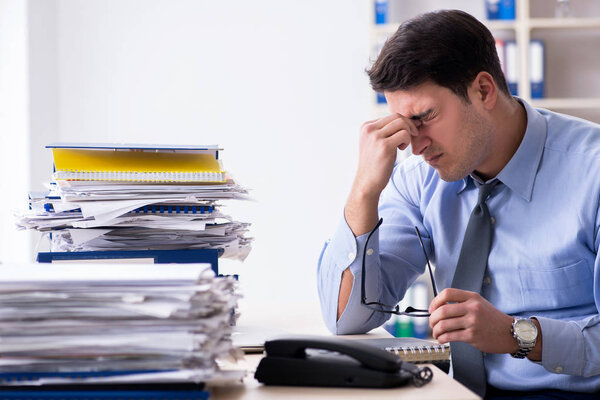 Extremely busy businessman working in office