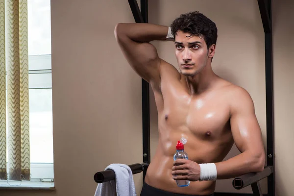 Hombre sediento bebiendo agua en el gimnasio deportivo — Foto de Stock