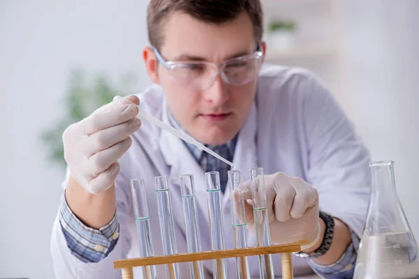 Fiatal kémikus diák kísérletezik a laborban — Stock Fotó