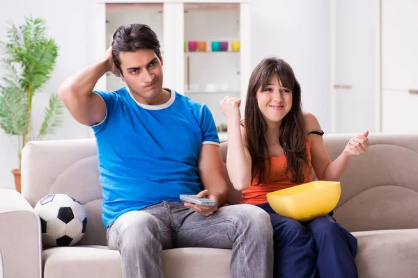 Genç adam evde karısıyla futbol seyrediyor. — Stok fotoğraf