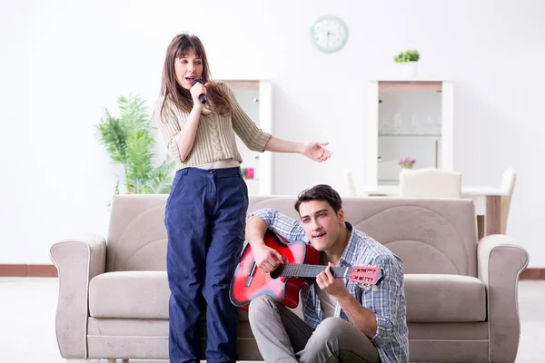 Família jovem cantando e tocando música em casa — Fotografia de Stock