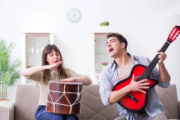 Jonge familie die thuis muziek zingt en speelt — Stockfoto