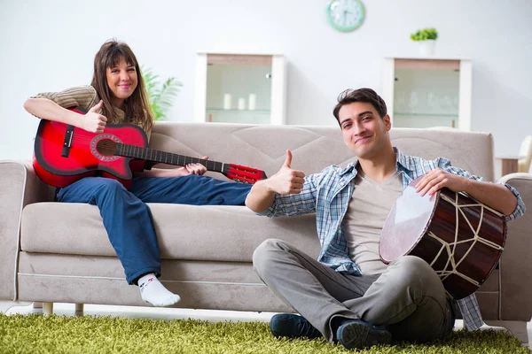 Família jovem cantando e tocando música em casa — Fotografia de Stock