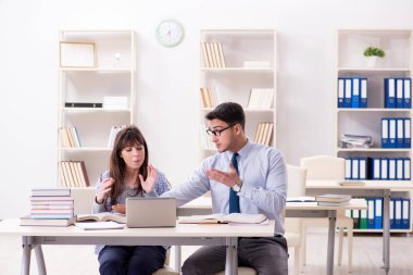 Erkek öğretim görevlisi bayan öğrenciye ders veriyor.
