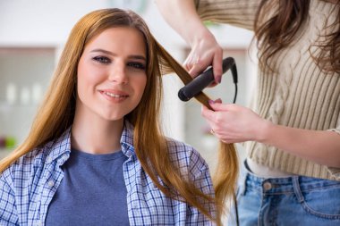 Kadın kuaförde saçını yaptırıyor.