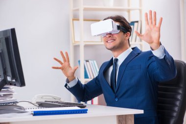Çalışan ofiste sanal gerçeklik gözlüğü kullanıyor.