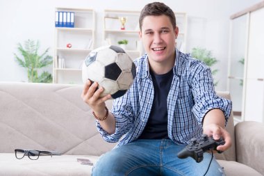 Genç adam evde bilgisayar oyunu oynuyor.