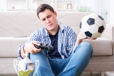 Genç adam evde bilgisayar oyunu oynuyor.