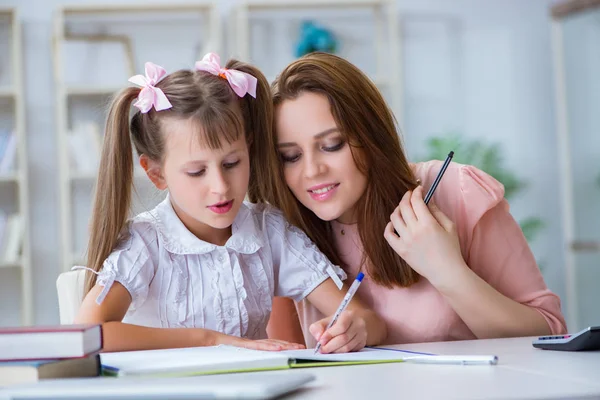Mother helping her daughter to do homework — Stock Photo, Image
