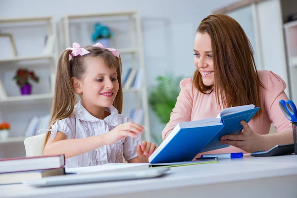 Mother helping her daughter to do homework — Stock Photo, Image
