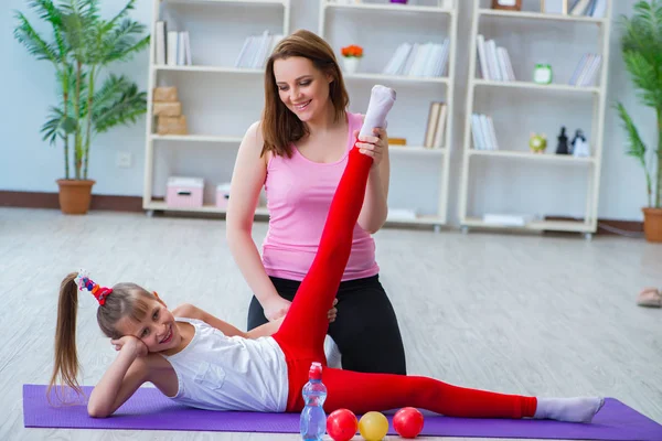 Meisje en moeder oefenen thuis — Stockfoto