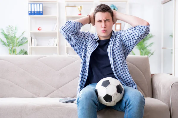 Jovem estudante assistindo futebol em casa — Fotografia de Stock