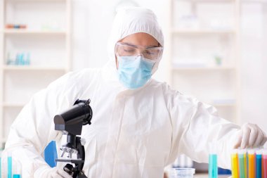 Laboratuvarda kimyasallar üzerinde çalışan genç bir kimyager.